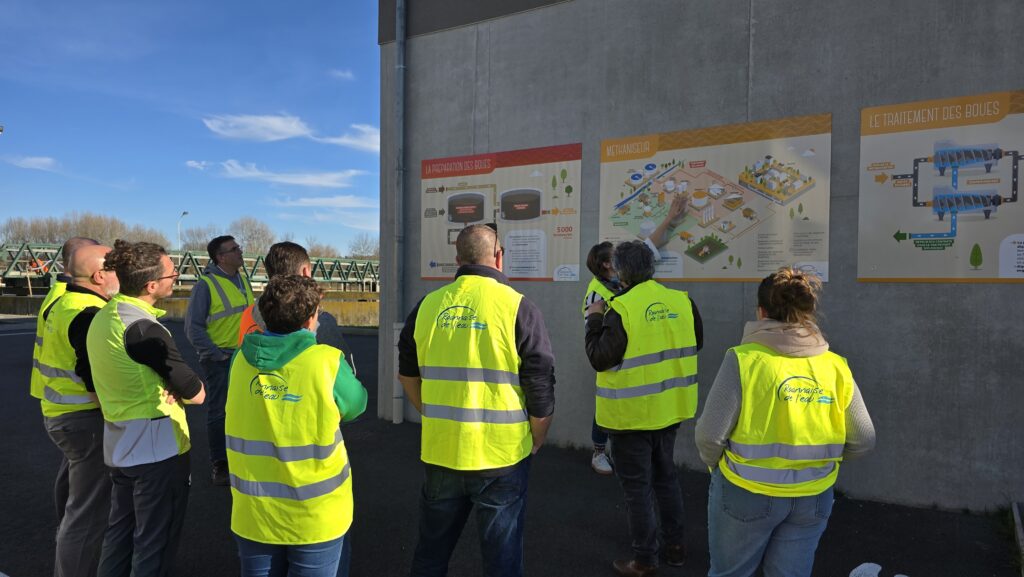 Agents de Roannaise de l'Eau devant des panneaux d'information technique